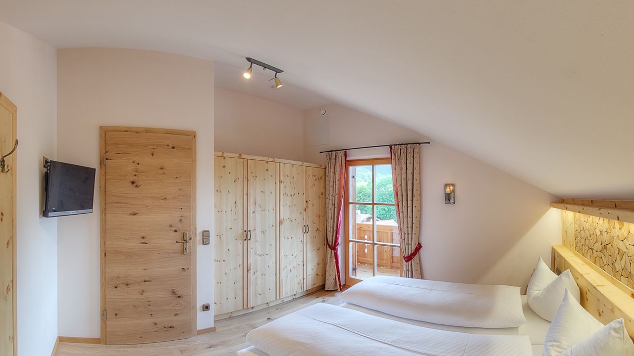 Schlafzimmer I mit maßgefertigter Zirbenholzausstattung, TV und Ostbalkon Schlafzimmer I mit maßgefertigter Zirbenholzausstattung, TV und Ostbalkon